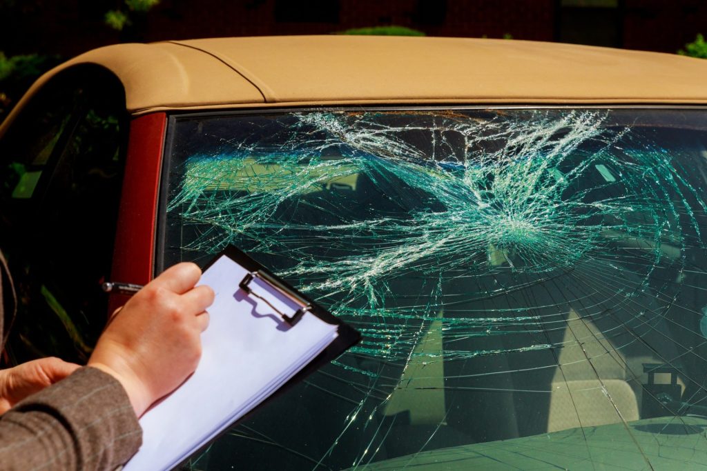 Insurance agent writing report on clipboard after car accident